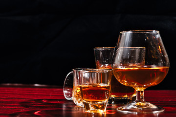 Brandy or liquor,Set of strong alcoholic drinks in glasses and shot glass on dark wood background