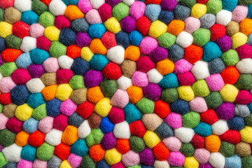 Fototapeta na wymiar Multicolored felt ball rug detail, colorful texture