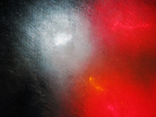 Abstract blurred multi-colored background. White and red marks from the car headlights on the wet glass. Selective focus.