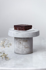 Vegan raw brownies with nuts and dates, on white marble background with copy space. Healthy dessert concept