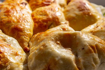 Bowl with delicious samosas on light background