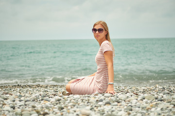 Fototapeta na wymiar Beautiful blond girl posing for photo at the national park in stripes dress