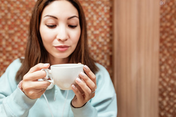 Happy asian woman drinking tea in cafe