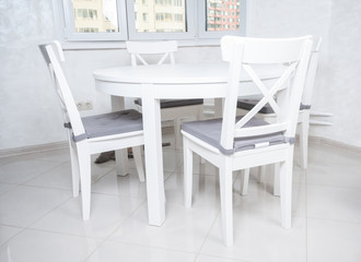 White wooden dining table and chairs in the kitchen