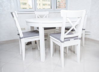 Fototapeta premium White wooden dining table and chairs in the kitchen