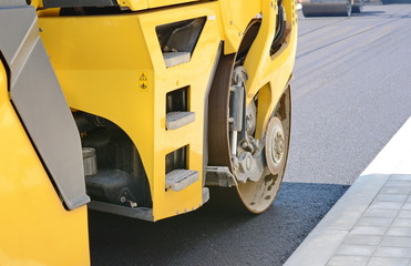 Road roller working on the new road construction site. Asphalting the road.