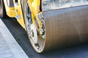 Road roller working on the new road construction site. Asphalting the road.