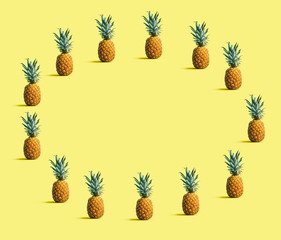 Fototapeta premium Round frame of pineapples on a solid color background