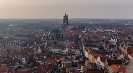 Obraz premium Fantastic Bruges city skyline with red tiled roofs and Saint-Salvator Cathedral tower in winter day. View to Bruges medieval cityscape from the top of the Belfry Tower.