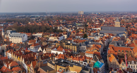 Fantastic Bruges city skyline with red tiled roofs and St. James's Church (Sint-Jakobskerk) in sunny winter day. View to Bruges medieval cityscape from the top of the Belfry Tower.