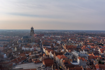 Fototapeta na wymiar Fantastic Bruges city skyline with red tiled roofs and Saint-Salvator Cathedral tower in winter day. View to Bruges medieval cityscape from the top of the Belfry Tower.