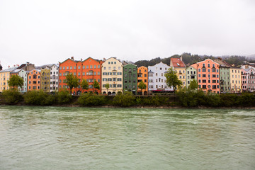 Fototapeta na wymiar Colorful houses in Innsbruck with Inn river in the background. Beautiful view of the historic city center of Innsbruck.
