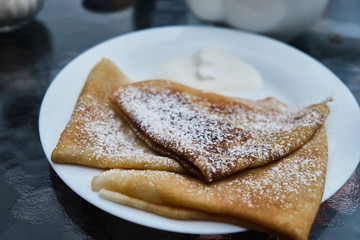 Pancakes in powdered sugar on plates