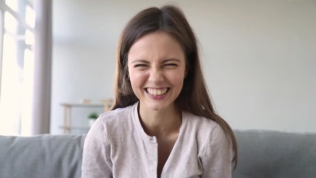 Happy girl talking video calling friend laughing looking at webcam