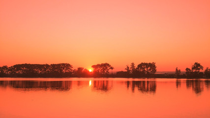 Beautiful summertime landscape with sunset over lake