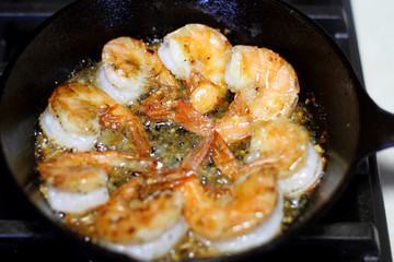 Shrimp Scampi cooking in a cast iron pan on the stove.