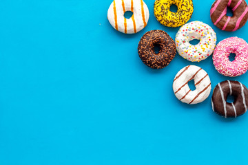 Modern design with bright donuts on blue background top view mock up