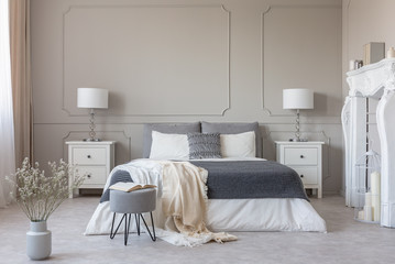 New york style bedroom interior with symmetric design, copy space on empty grey wall - obrazy, fototapety, plakaty