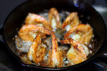 Shrimp Scampi cooking in a cast iron pan on the stove.