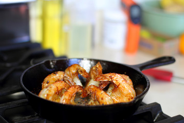 Shrimp Scampi cooking in a cast iron pan on the stove.