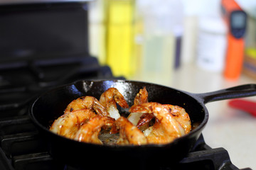 Shrimp Scampi cooking in a cast iron pan on the stove.
