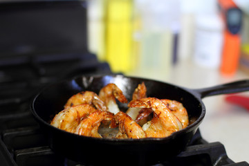Shrimp Scampi cooking in a cast iron pan on the stove.