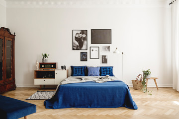 Mockup gallery on the wall of navy blue vintage bedroom in tenement house.Real photo concept
