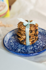 asty homemadeoats cookies decorated of blue satin ribbon on the creative bright blue plate