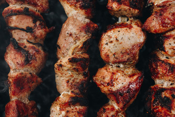 Closeup of some meat skewers being grilled in a barbecue