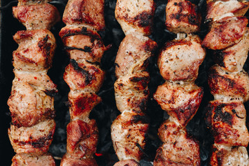 Closeup of some meat skewers being grilled in a barbecue