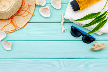 Planning vacation to the seaside with straw hat, sun glasses, sunscreen lotion on mint green background top view mock-up