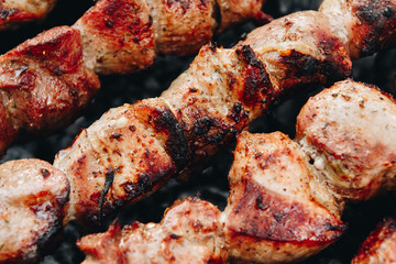 Closeup of some meat skewers being grilled in a barbecue