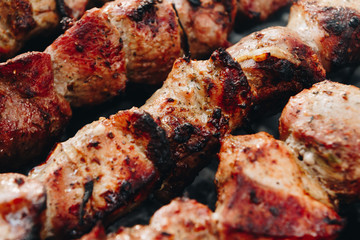 Closeup of some meat skewers being grilled in a barbecue
