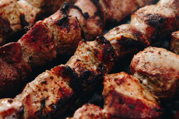 Closeup of some meat skewers being grilled in a barbecue