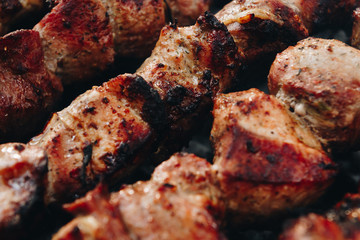 Closeup of some meat skewers being grilled in a barbecue