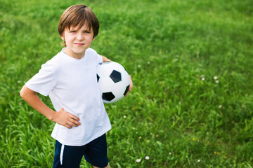 Boy with a soccer ball on the grass.