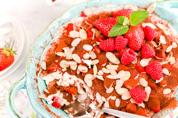 Traditional Italian cake with mascarpone cheese and berries. Tiramisu with raspberry berries and espresso coffee. Homemade breakfast. Copy space.
