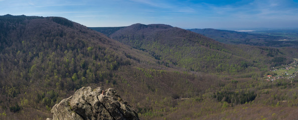 Panoramic landscape of Jizera Mountains jizerske hory, view from peak oresnik mountain with lush green spruce tree forest, hills and village Hejnice, blue sky background