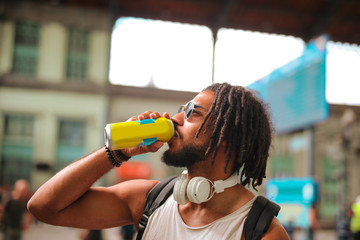 Young Afro handsome man having a drink - obrazy, fototapety, plakaty