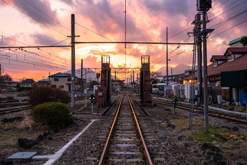 Straight railroad track under colourful sky at sunset. Fujikawaguchiko, Japan.