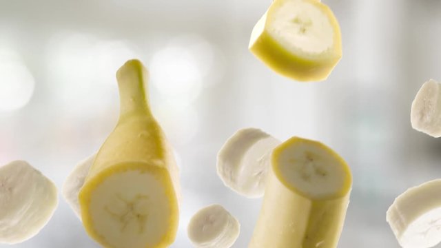 Banana with Slices Falling on Kitchen Background
