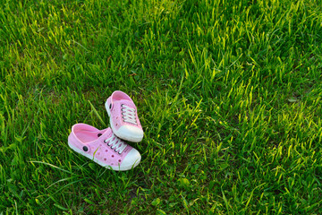 Fototapeta premium Colorful children sandals on playground made of artificial grass photo