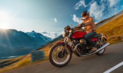 Fototapeta na wymiar Motorcycle driver riding in Alpine highway, Nockalmstrasse, Austria, central Europe.