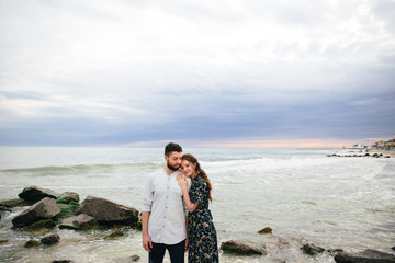 beautiful couple in love hugging on the beach. Standing on the beach on the sea background