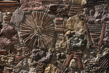 Fototapeta na wymiar Mexican Sun God patterns relief in stone and tile wall Baston del Rey Mexico