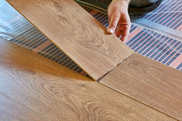 Laying laminate covering on heat-insulated floor