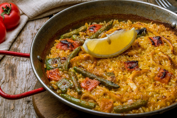 paella with squid on wooden background