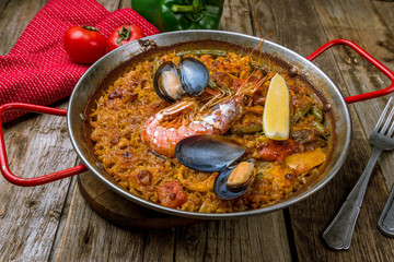 paella with seafood on wooden background