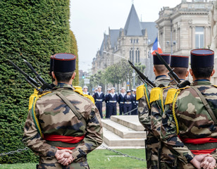 Rear view of unrecognizable French soldiers paying tribute at ceremony to mark Western allies World War Two victory Armistice in Europe marking the 72nd anniversary victory over Nazi Germany in 1945.