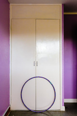 Hula Hoop against a wardrobe in an empty, abandoned bedroom (updated version of BRJ09W)